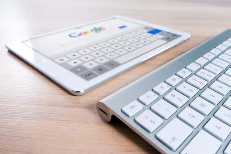 En pad ligger på et bord med Google-logoen synlig Googles algoritmer står parate til å rangere hva enn brukeren søker på.